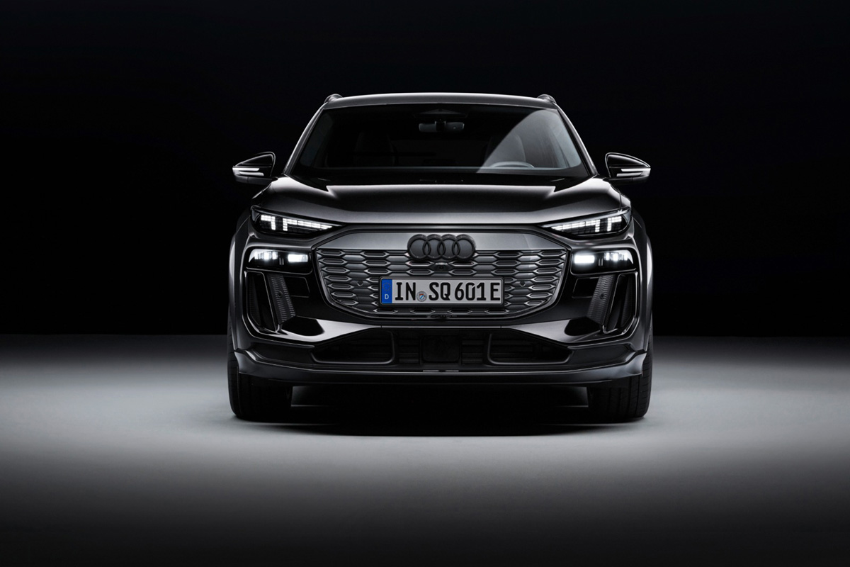 Sprednji pogled na črn Audi SQ6 SUV e-tron pred temnim ozadjem.