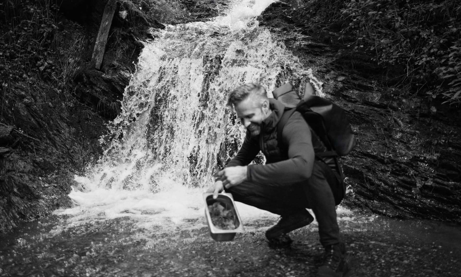 Vitus Winkler nabira zelišča ob gorskem potoku.