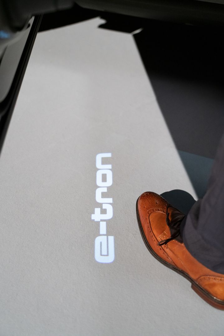 Logotip e-tron, projiciran na tla pod voznikovimi vrati. 