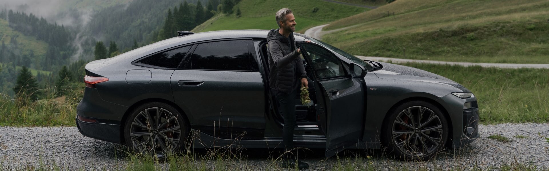 Vitus Winkler stoji ob odprtih sovoznikovih vratih modela Audi A6 Sportback e-tron. 