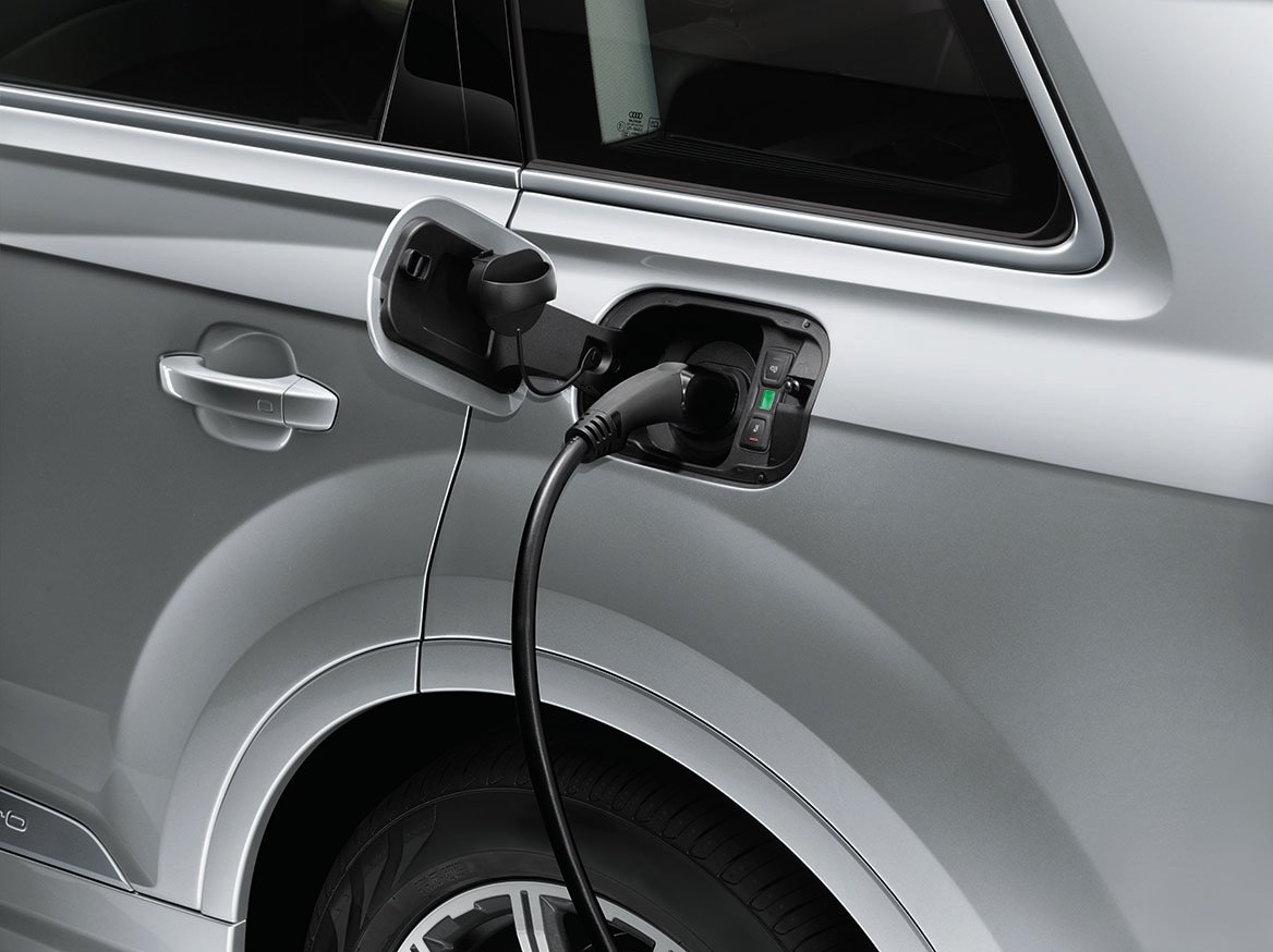 Na sliki srebrn Audi avtomobil, med električnim polnjenjem