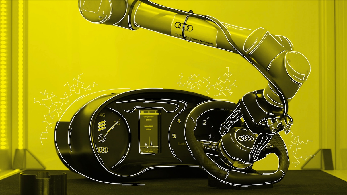 Robotska roka, med pritrjevanjem Audi volana na armaturno ploščo. Slika ima rumen filter