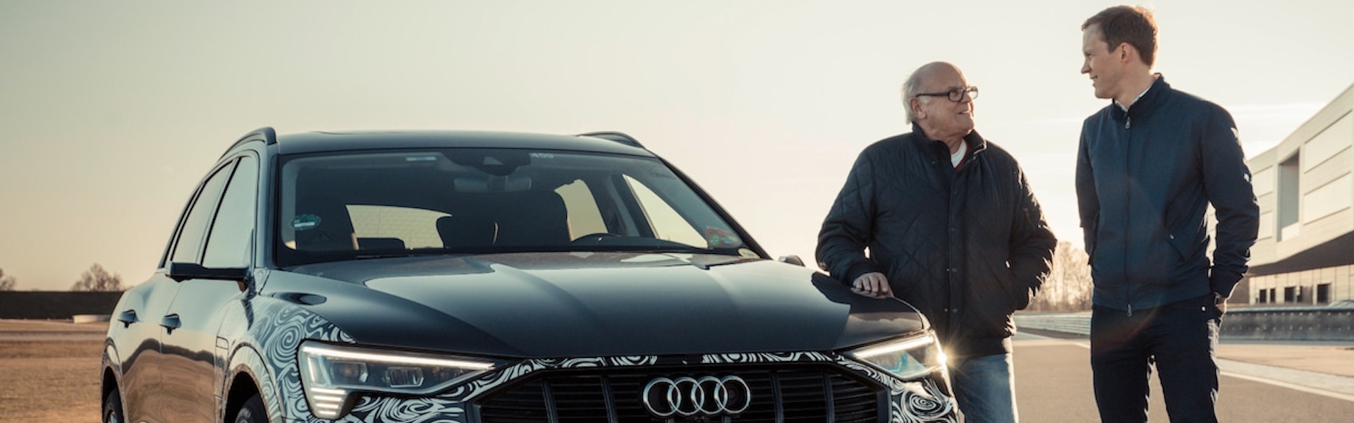 Stig Blomquist in Mattias Ekström stojita ob Audi e-tron avtomobilu.