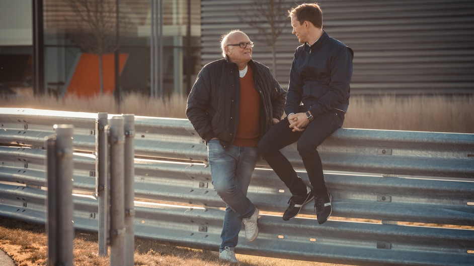 Stig Blomqvist in Mattias Ekström med pogovorom ob zaščitni ograji na stezi.