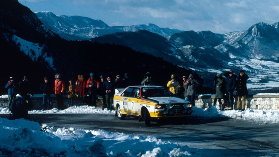 Slika iz WRC 1984. Rumen Avdi dirkalni avto na zasneženi cesti pred skupino ljudi.
