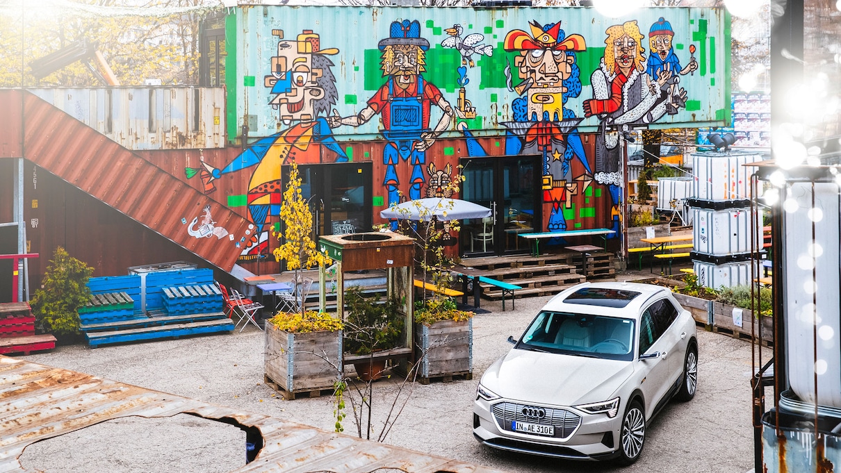 Audi e-tron na dvorišču pred živo pobarvano zgradbo