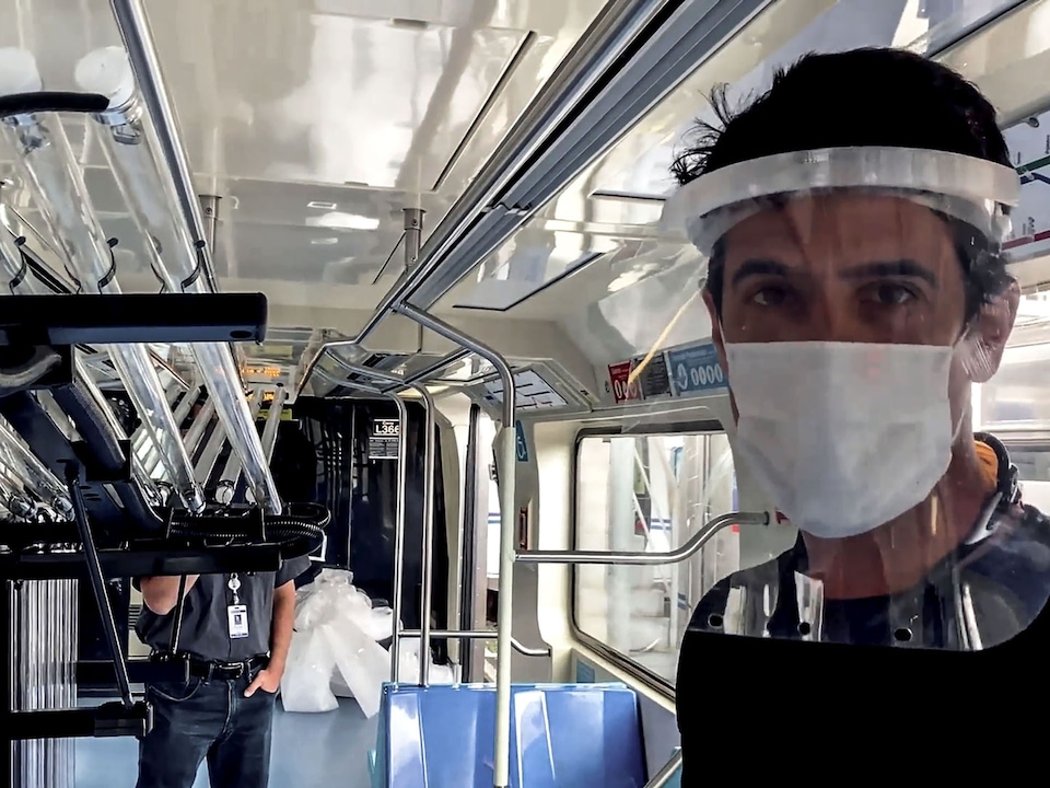 Lucas di Grassi z masko in vizorjem, med vožnjo na avtobusu