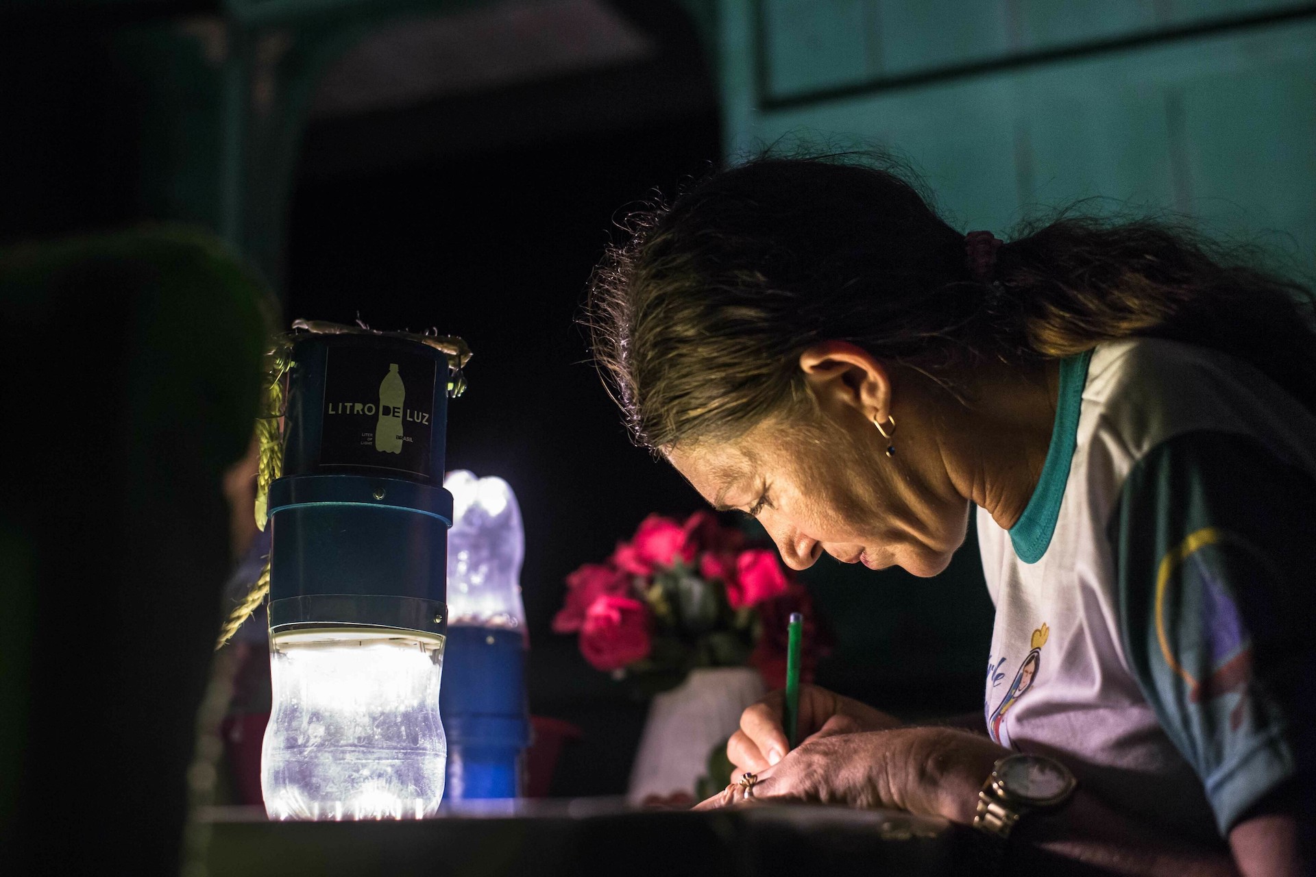 Vaščanka amazonske vasi uporablja svetilko na solarno energijo