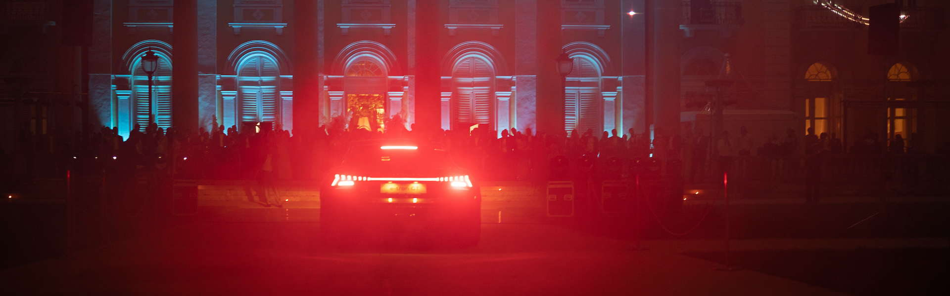 Audi e-tron GT z laserskim šovom v ozadju.