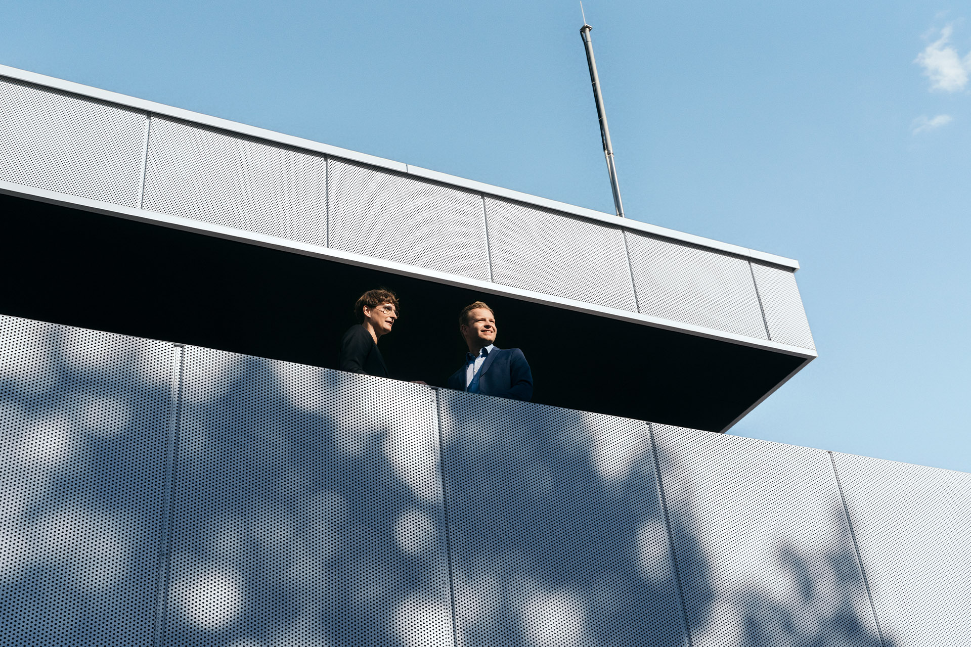 Strokovnjaka za trajnostni razvoj dr. Johanna Klewitz in Malte Vömel na balkonu salona v polnilnem središču Audi charging hub.