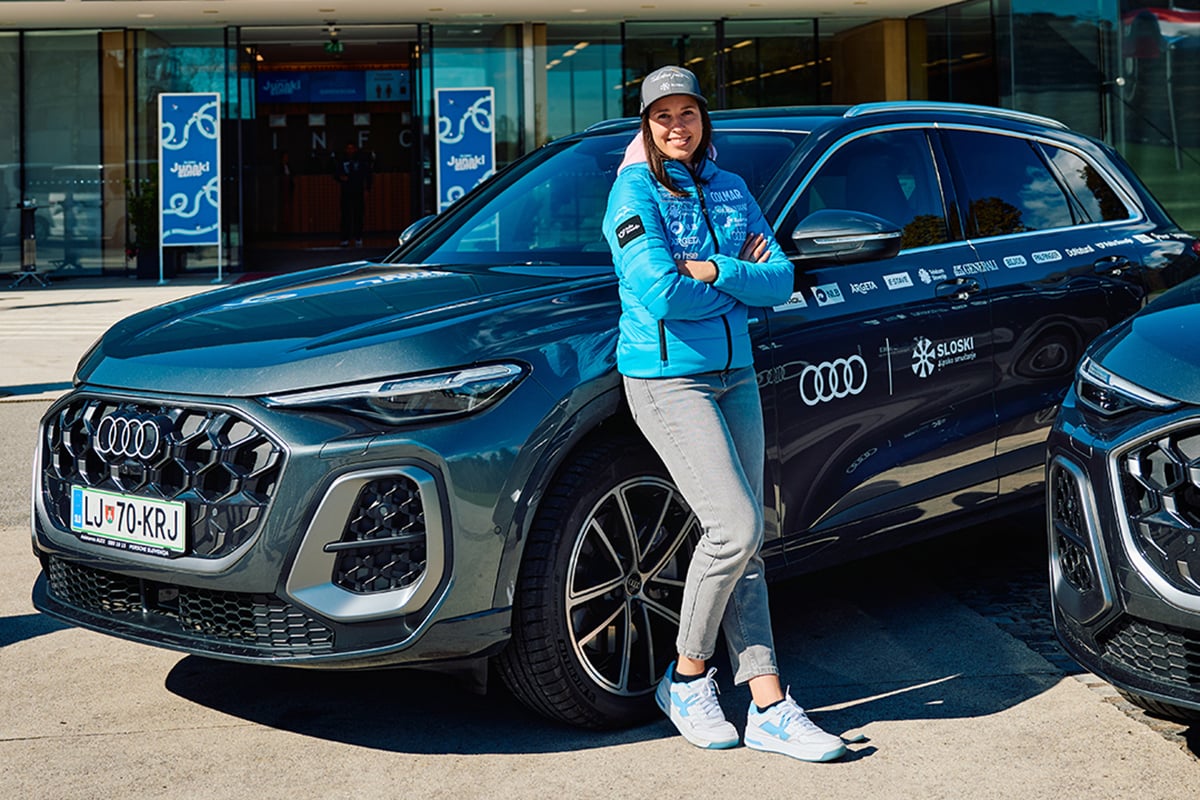 Nika Tomšič stoji pred avtomobilom Audi Q5.