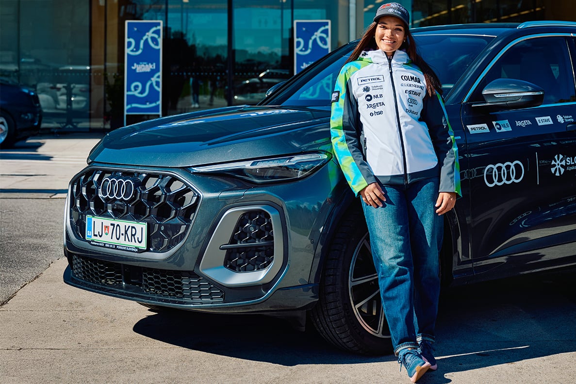 Caterina Sinigoi stoji pred avtomobilom Audi Q5.