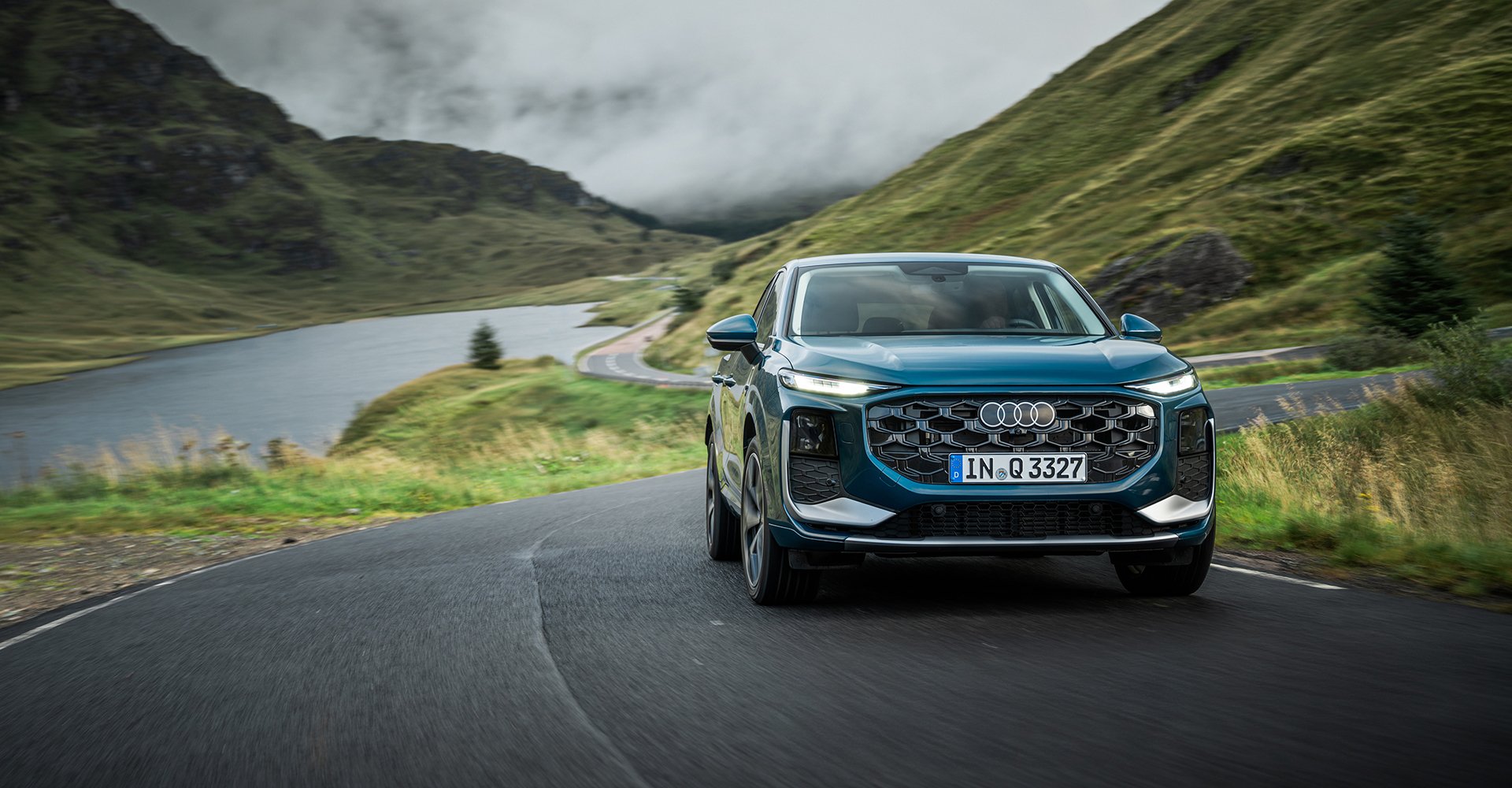 Dinamična fotografija Audi Q3 v naravi, prikaz zunanjosti s sprednjega pogleda.