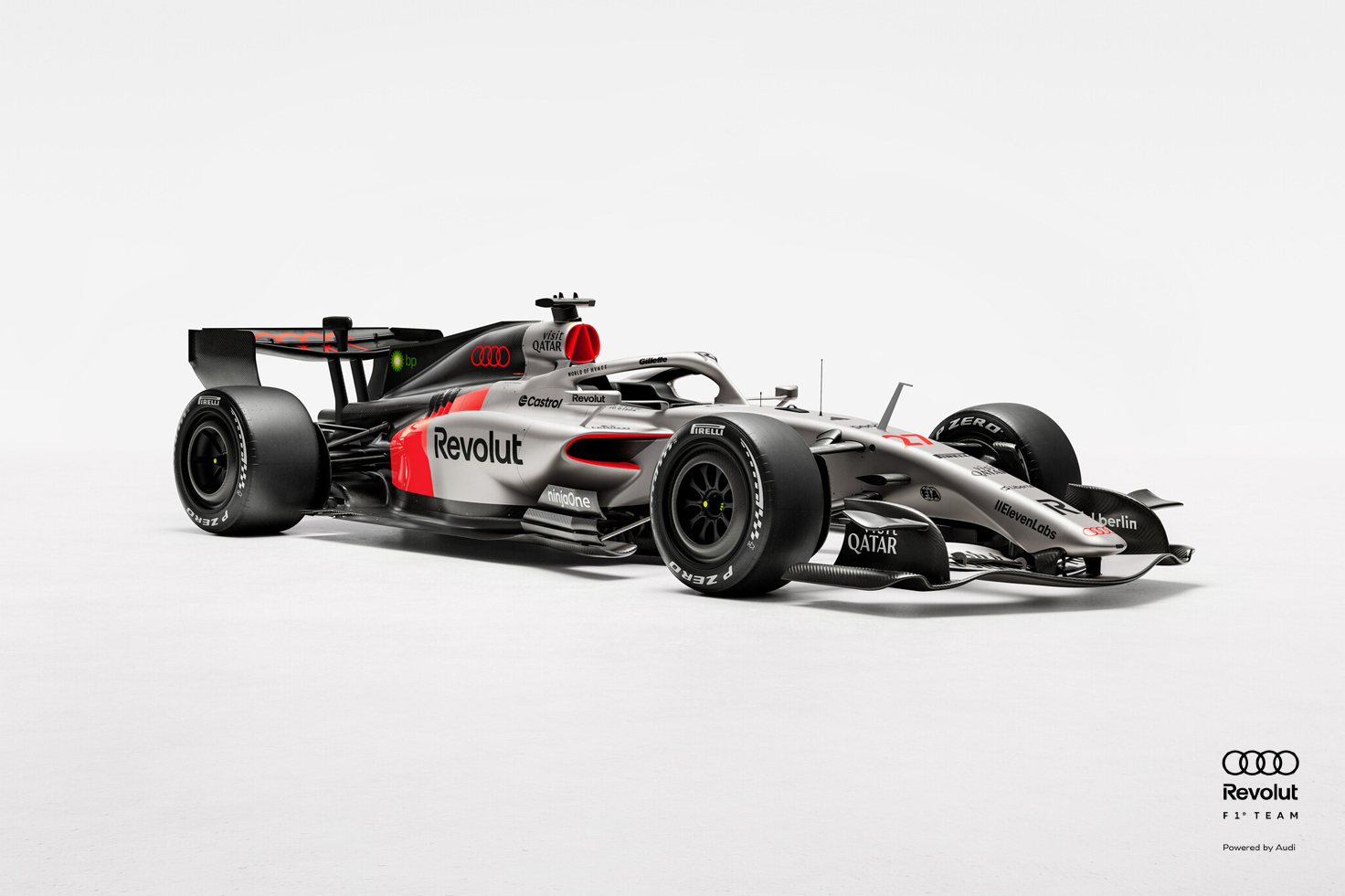 Dirkalnik Audi R26 za Formulo 1® v črno-sivo-rdeči barvni shemi v temnem studiu, osvetljen s strani, na njem so vidni logotipi sponzorjev..
