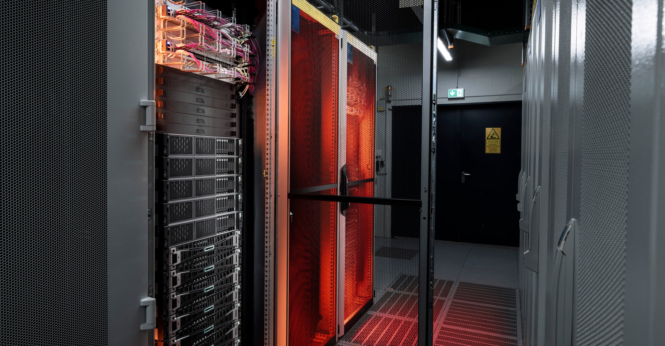 Strežniki sistema Edge Cloud, osvetljeni z oranžno svetlobo.