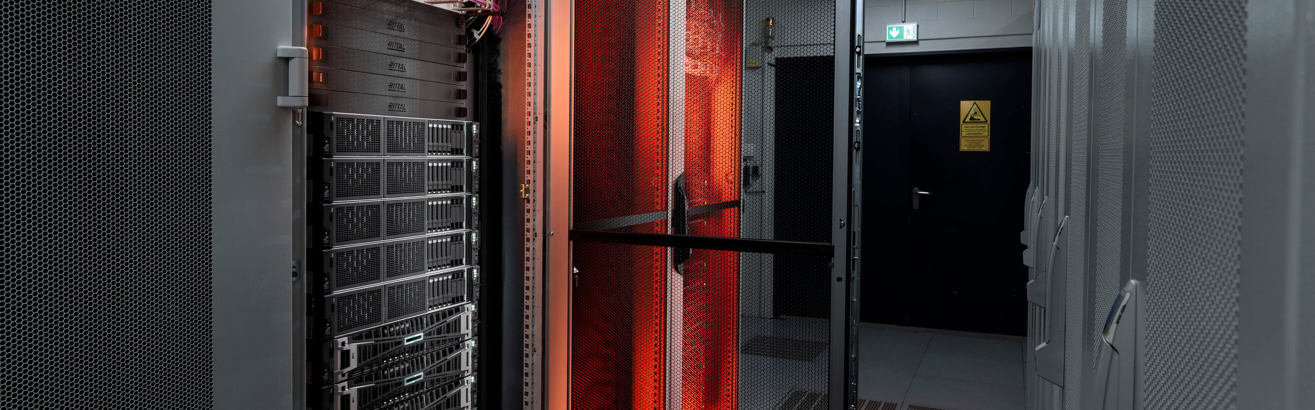 Strežniki sistema Edge Cloud, osvetljeni z oranžno svetlobo.