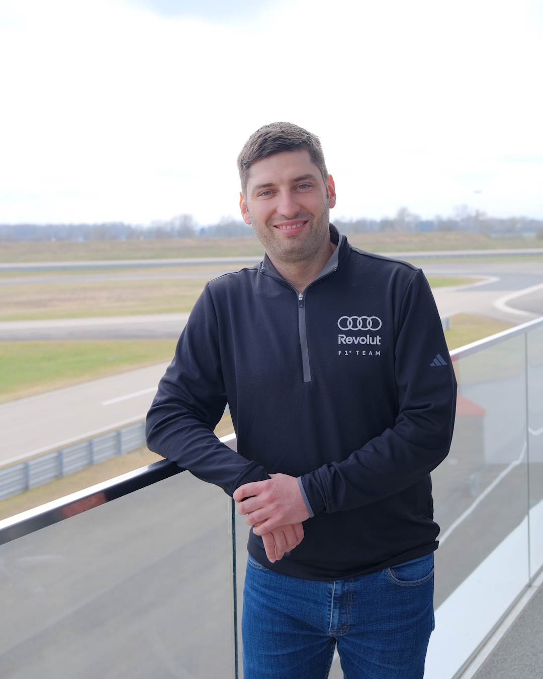 Matej Reich, razvijalec v ekipi Audi F1 s pogledom na dirkaško stezo na sedežu podjetja Audi Sport v Neuburgu